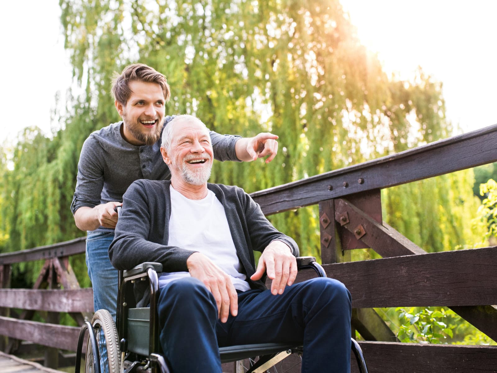 A Calgary caregiver out with a smiling senior in a wheelchair